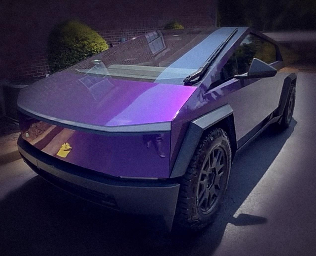 Purple Cybertruck parked in front of a brick building